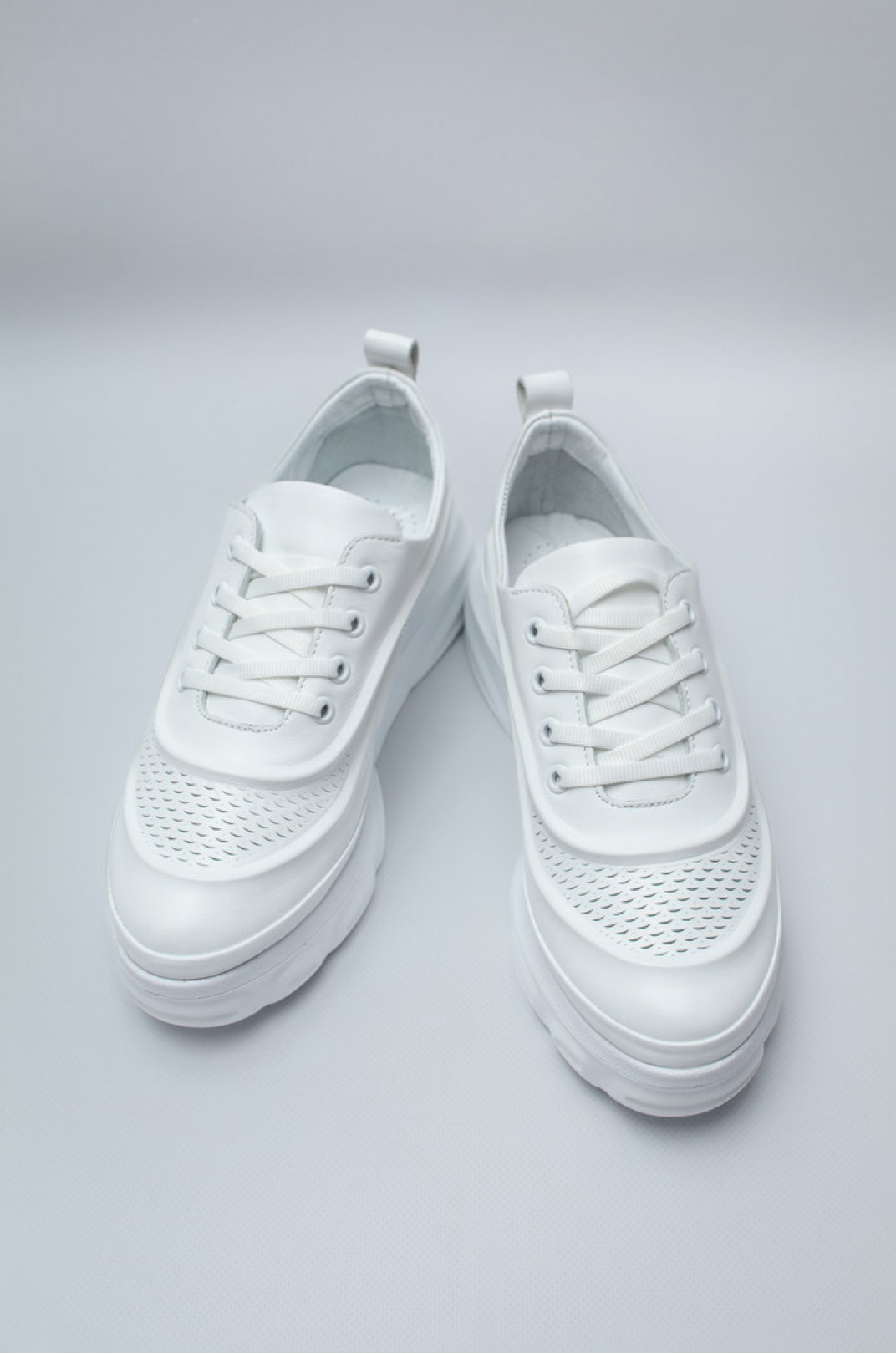 Стильні білі кросівки з перфорацією великих розмірів