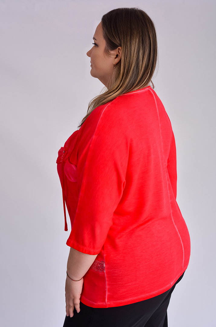 Червона блуза декорована квіткою та паєтками великих розмірів