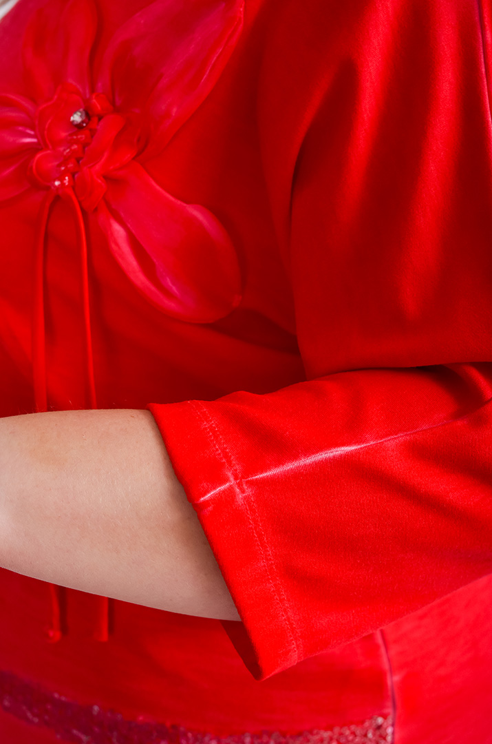 Червона блуза декорована квіткою та паєтками великих розмірів