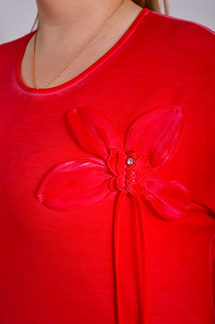 Червона блуза декорована квіткою та паєтками великих розмірів